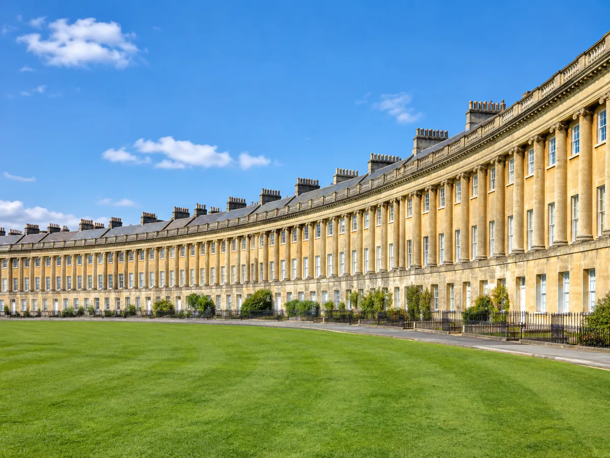 Der Royal Crescent in Bath an einem sonnigen Tag mit einem Rasen im Vordergrund